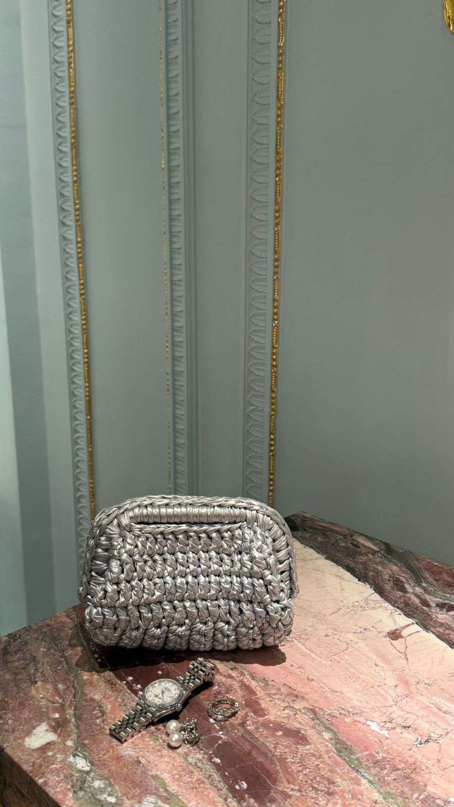 Small woven bag on a textured surface with a light gray wall in the background