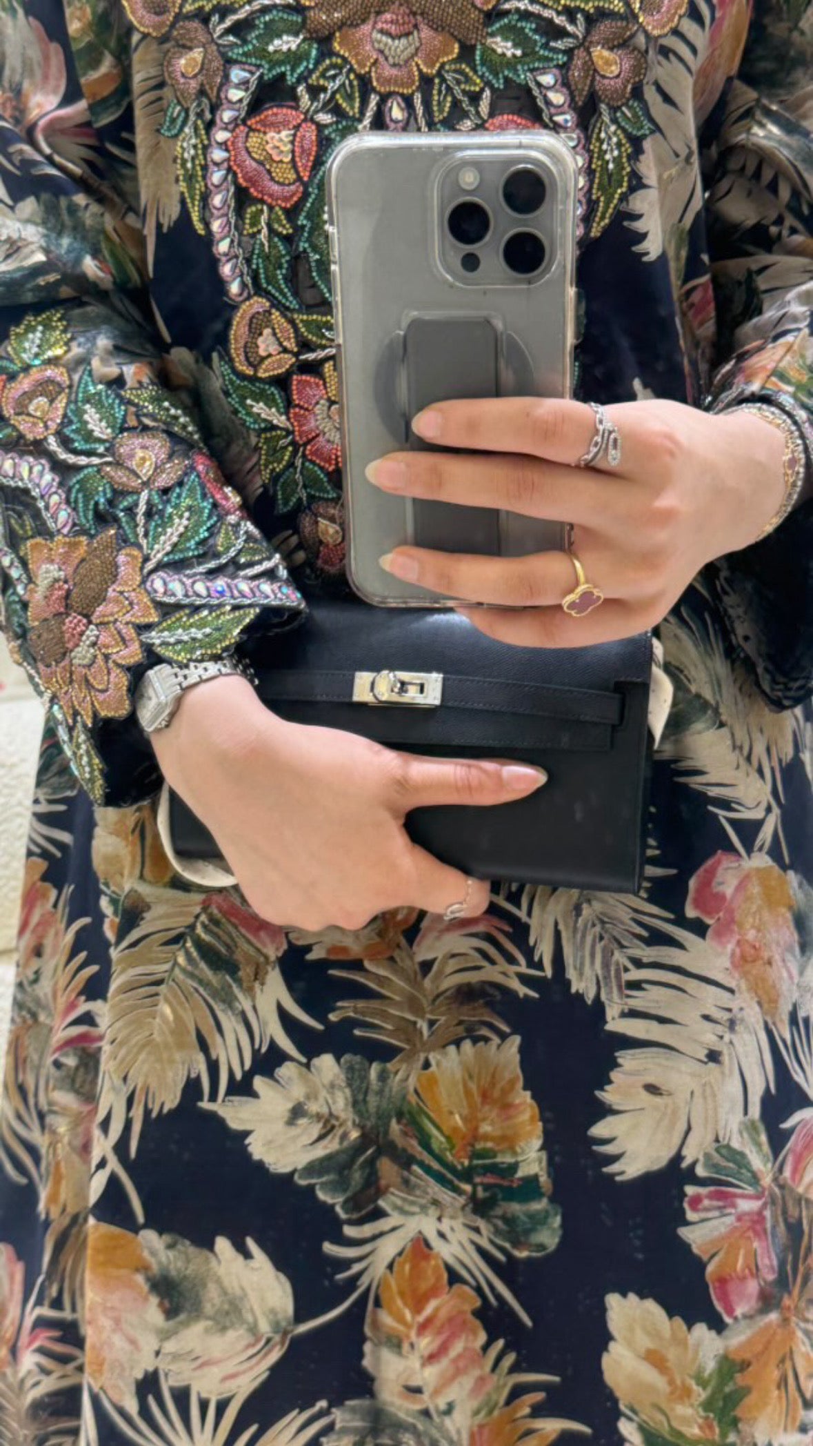 Person holding a phone and wallet with floral patterned fabric background