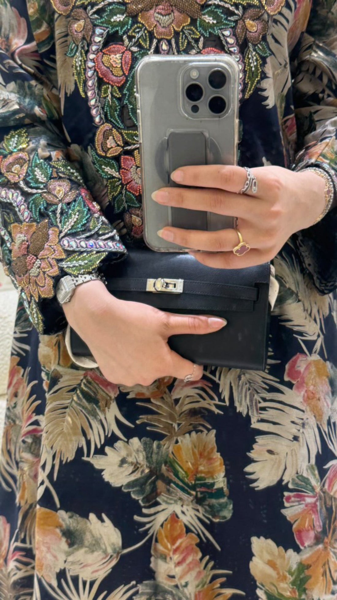 Person holding a phone and wallet with floral patterned fabric background