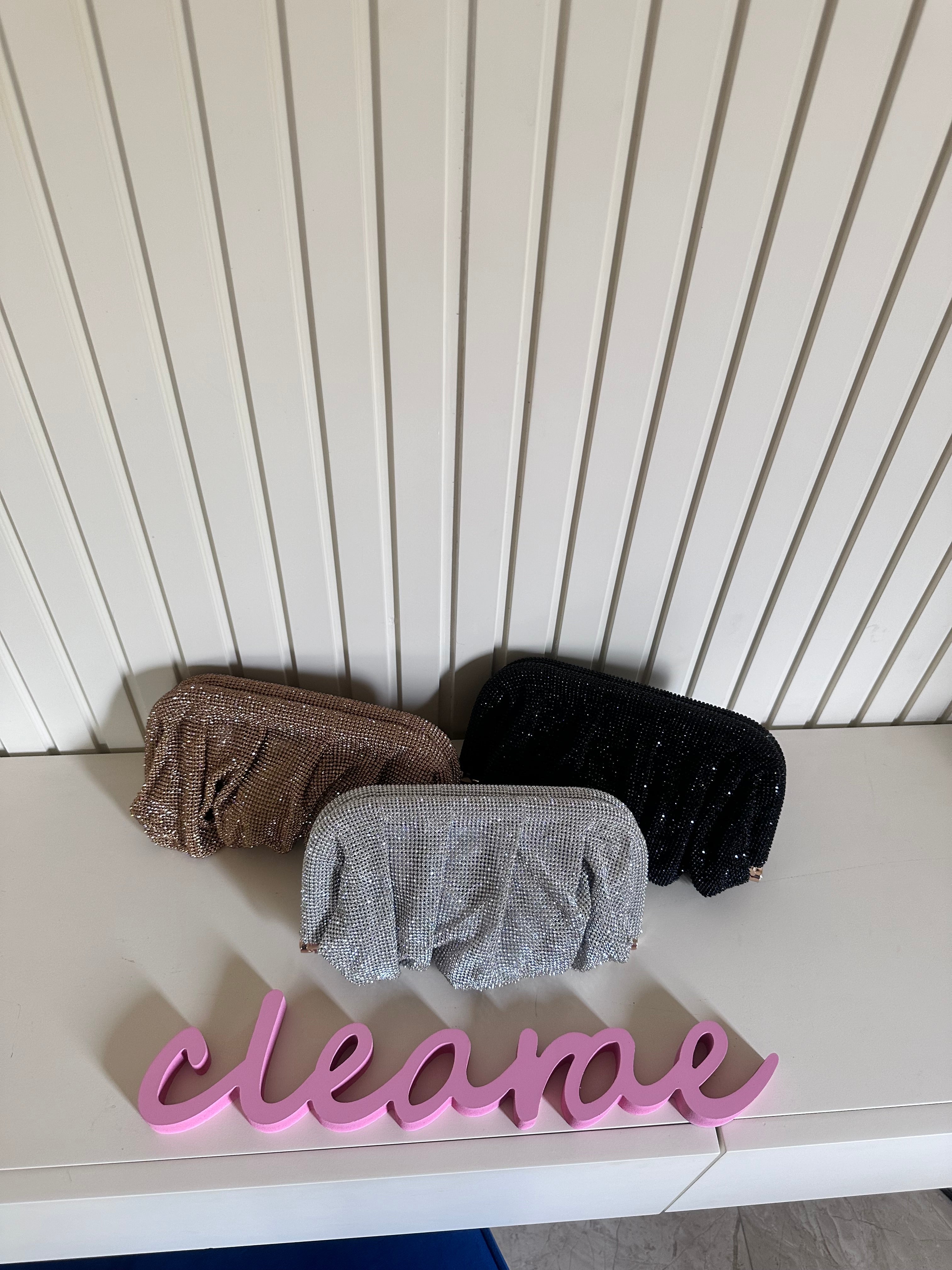 Three sponges on a white surface with a 'clean' sign in front of a white paneled wall.