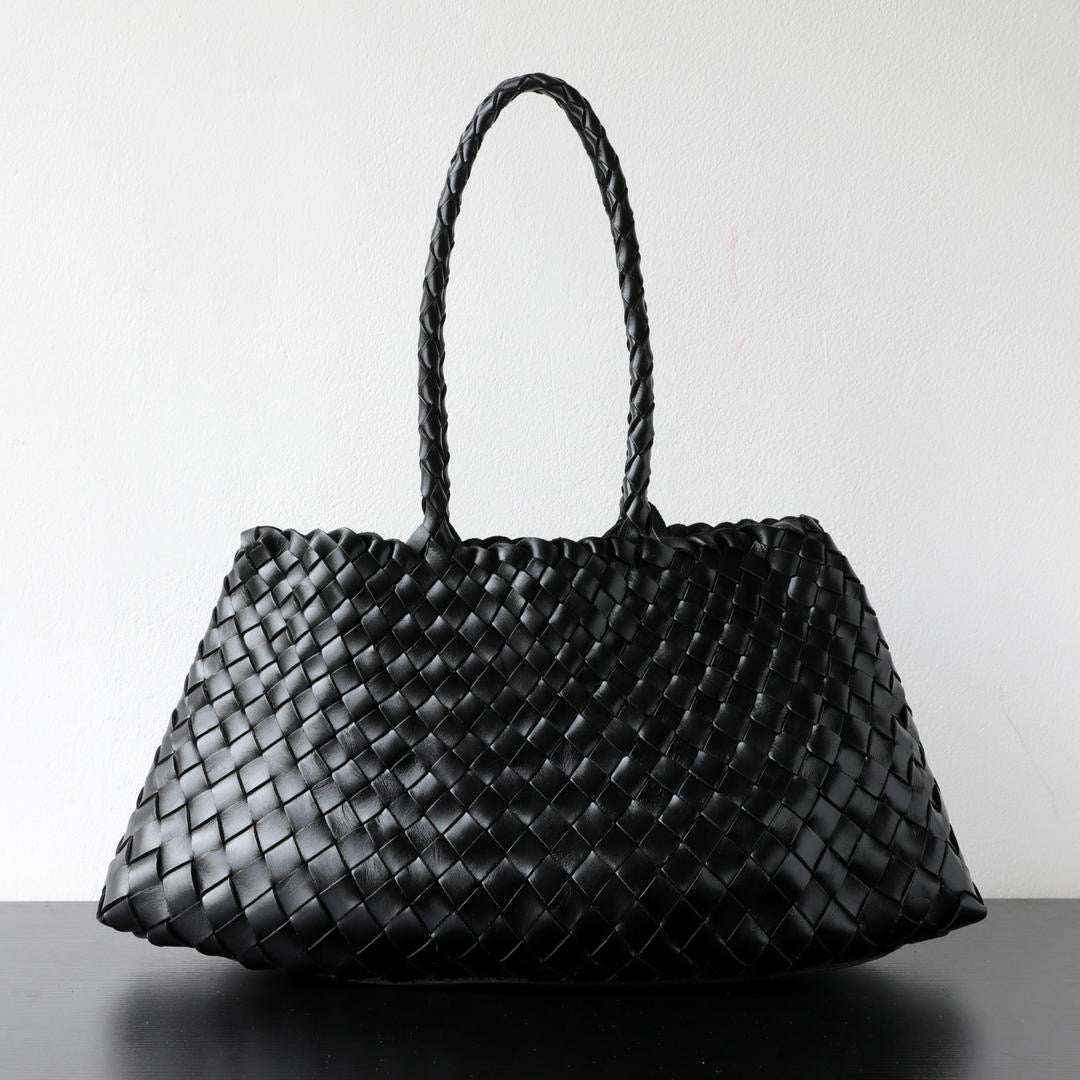 Black woven handbag on a light gray background
