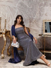 Woman in a formal gown sitting in an elegant room with decorative elements.