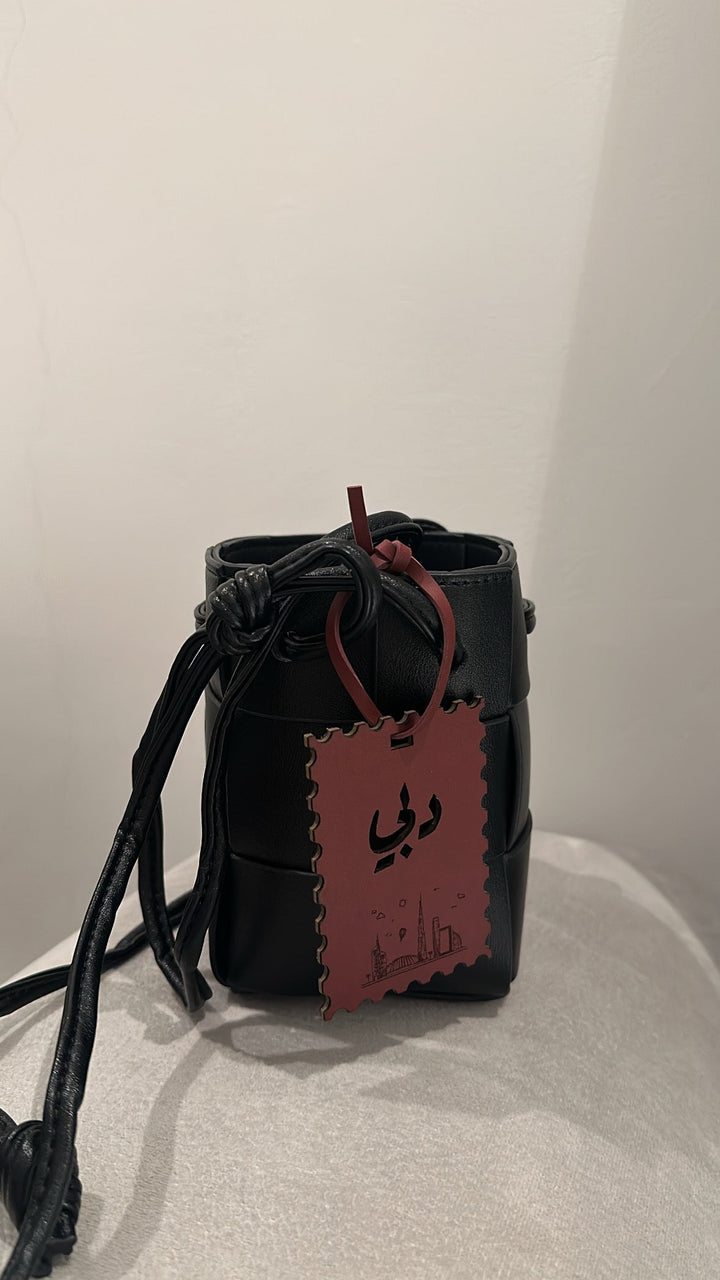 Black container with a red tag on a white surface