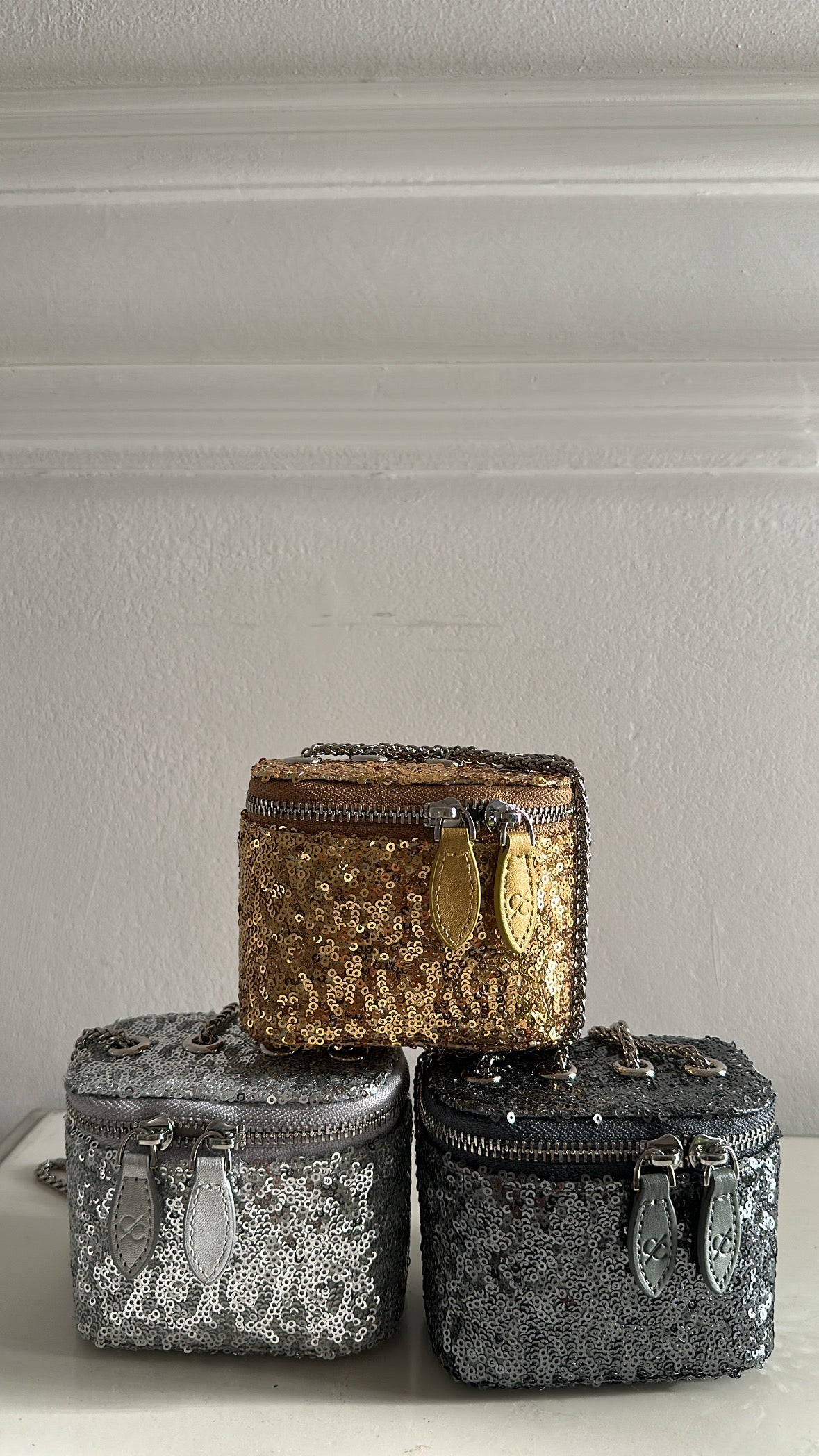 Three decorative boxes with gold, silver, and black patterns on a neutral background