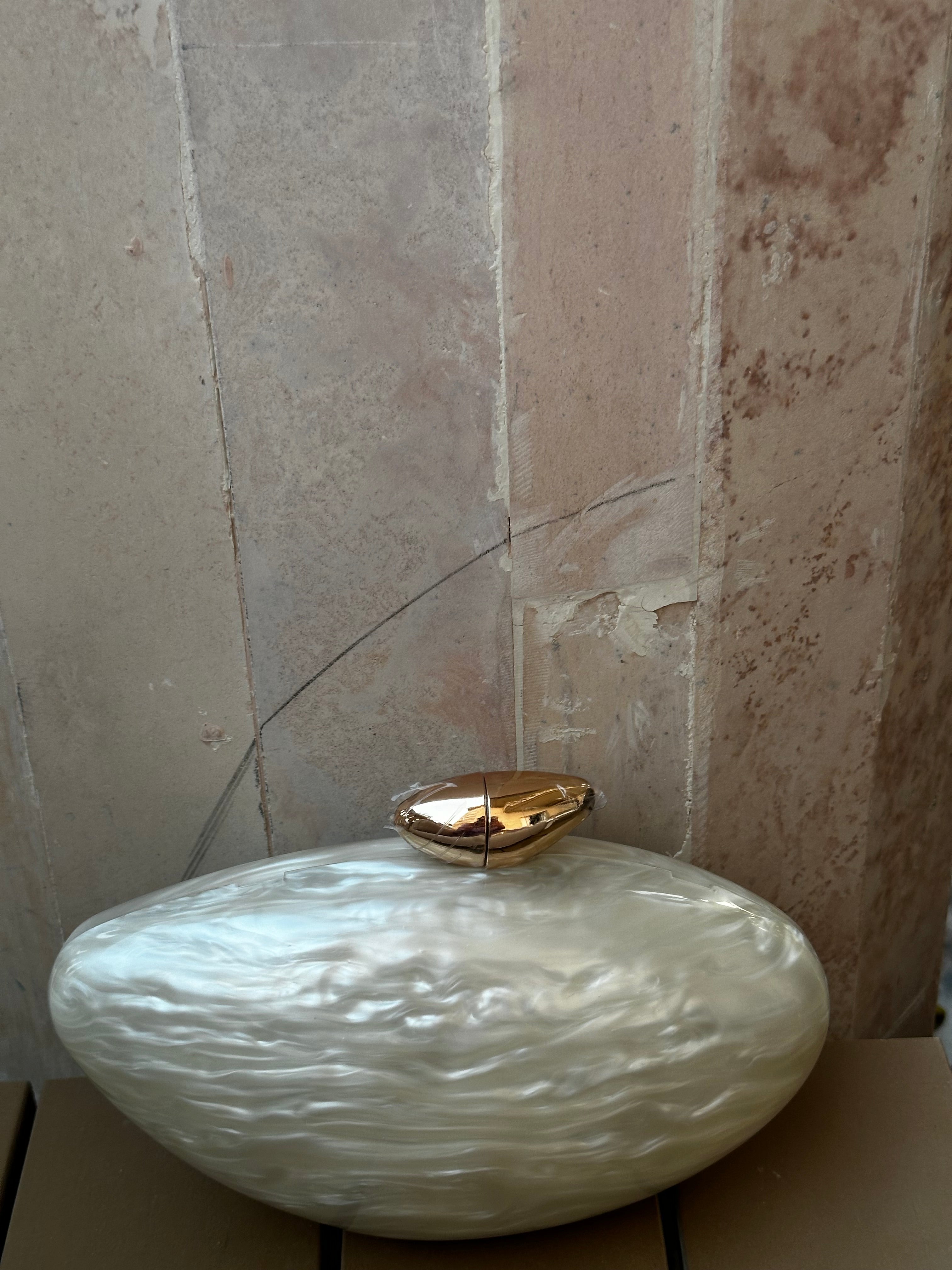 Decorative vase with textured surface and gold accent on a marble background
