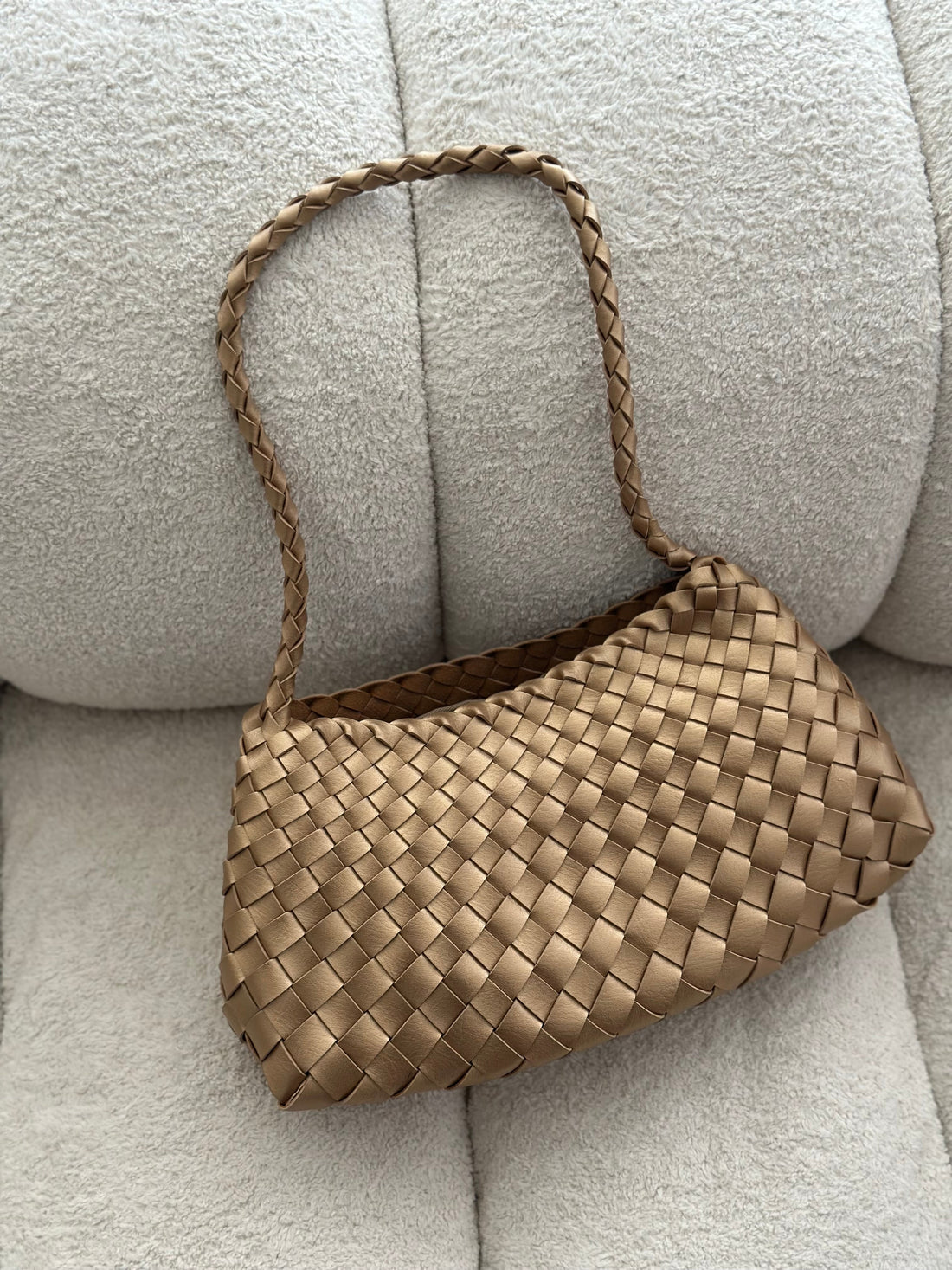 Woven handbag on a light gray sofa