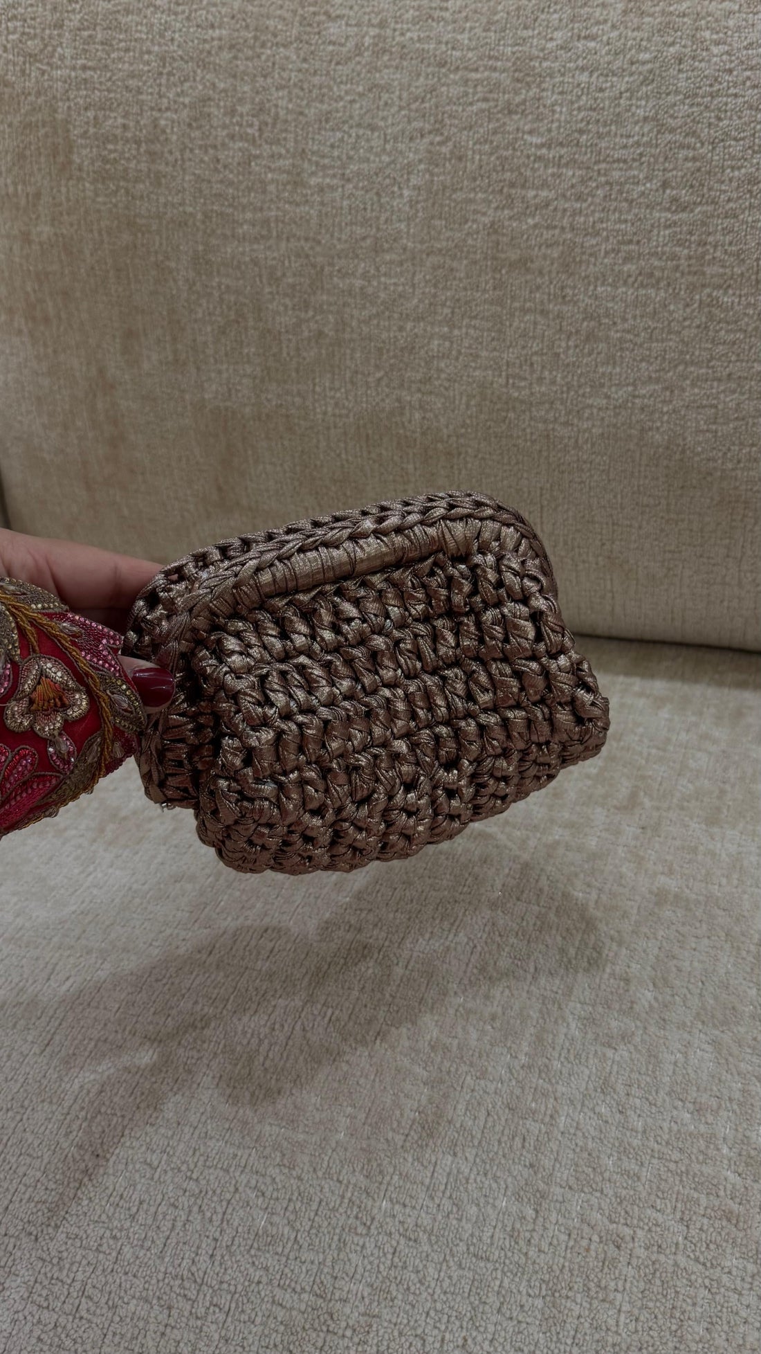 Handheld woven basket on a beige surface