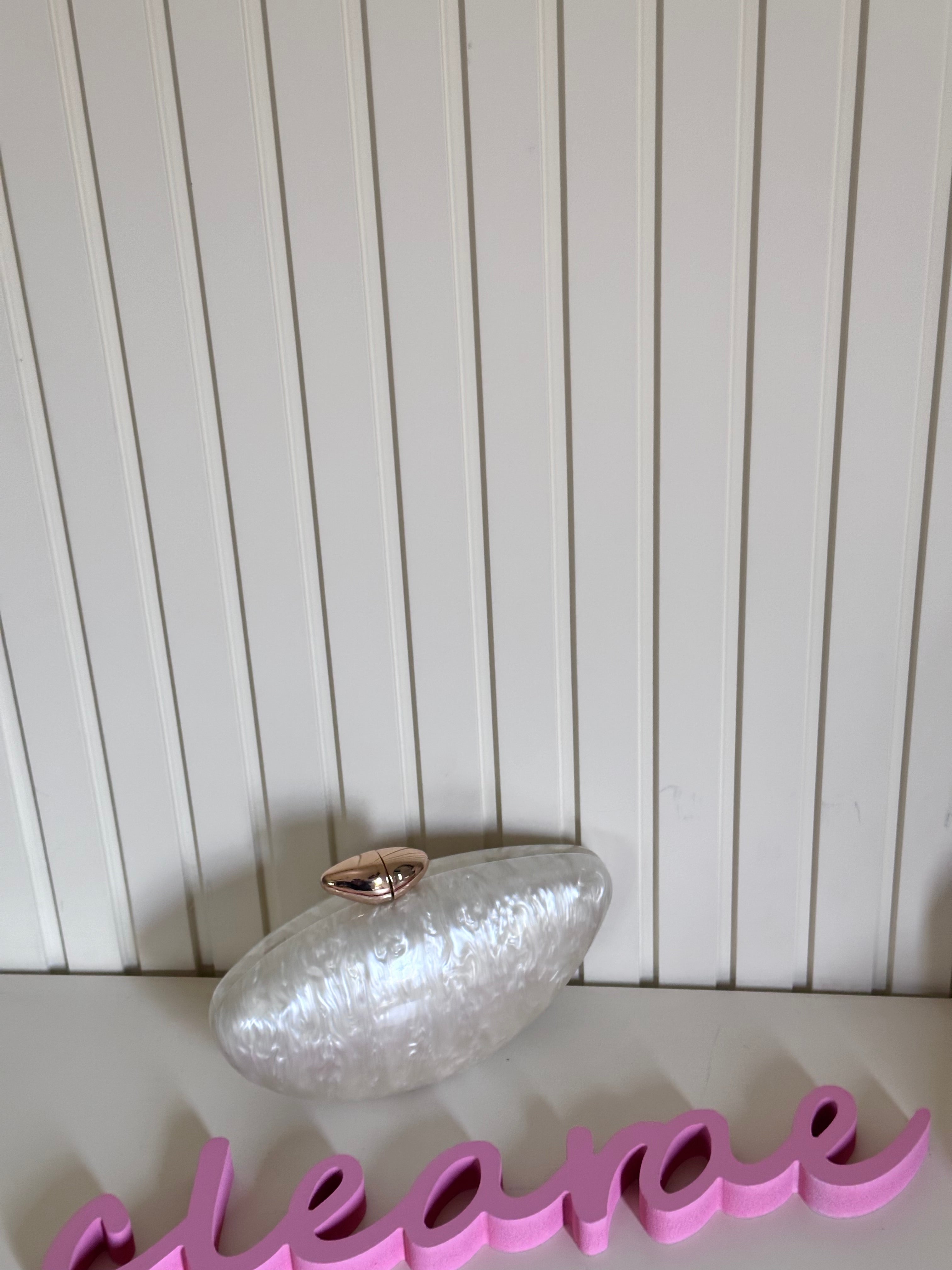 Clear decorative object on a white surface with a pink word in the foreground