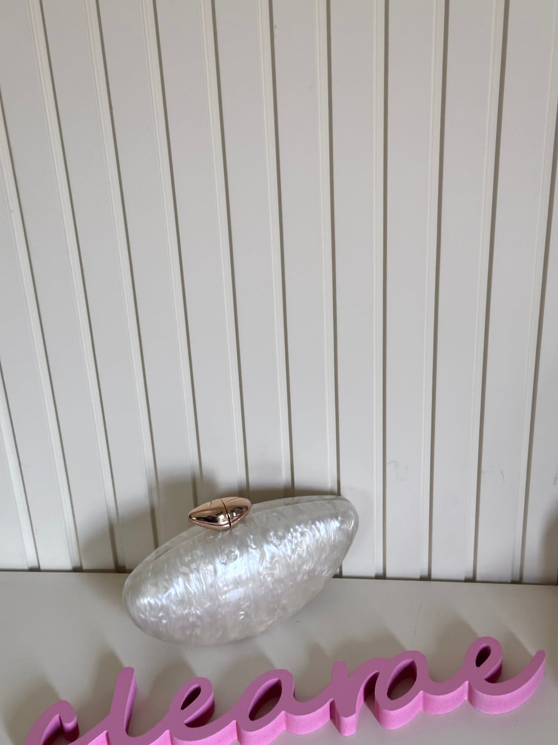 Clear decorative object on a white surface with a pink word in the foreground