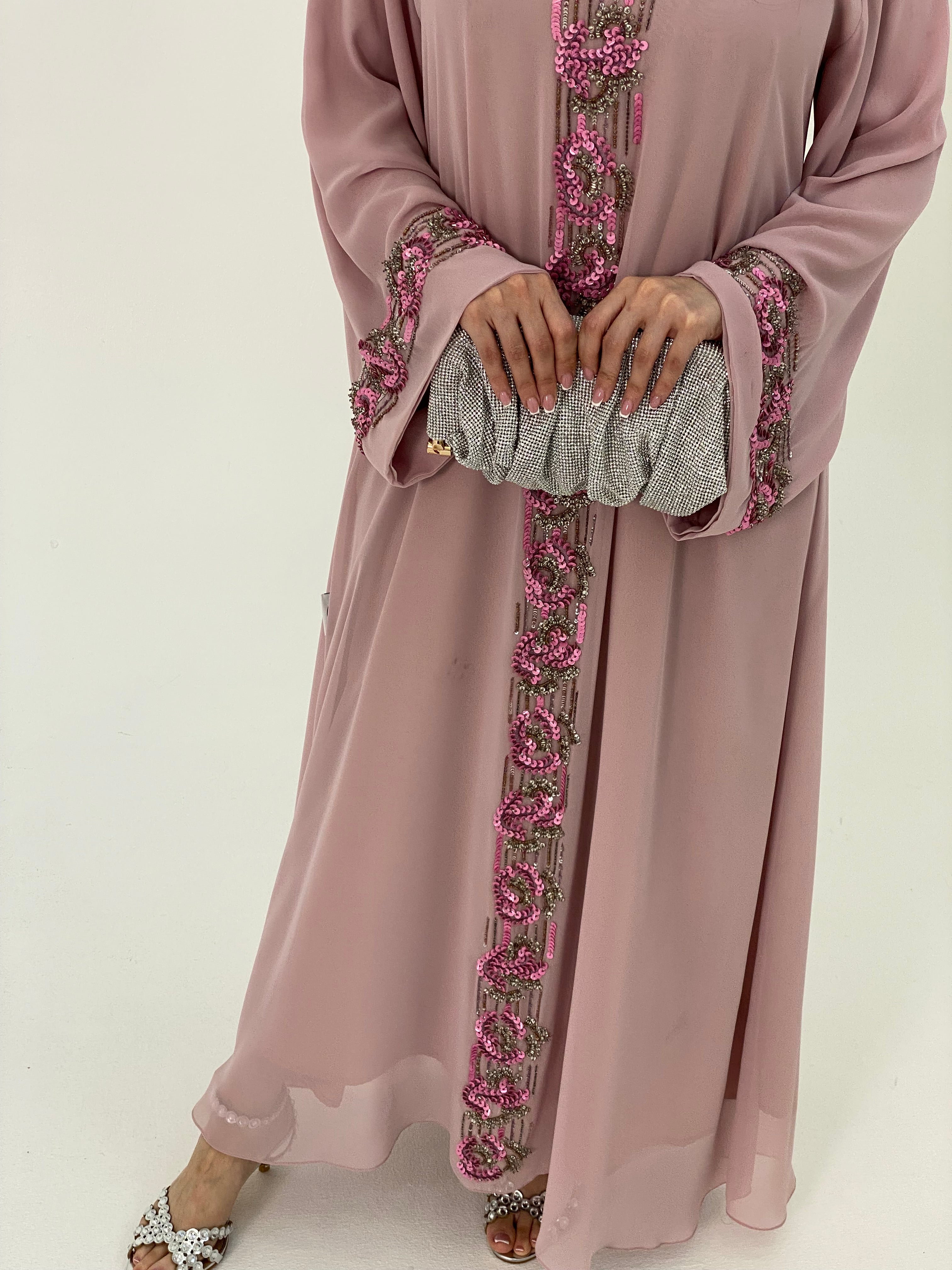 Pink dress with floral embroidery on a white background