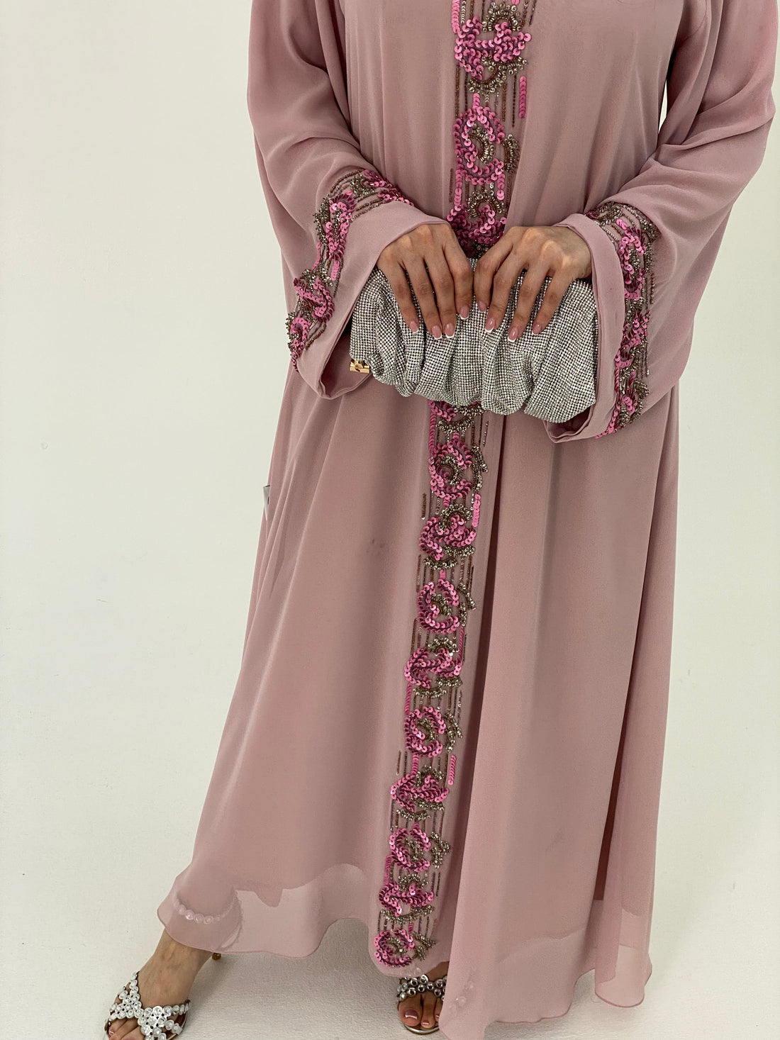 Pink dress with floral embroidery on a white background