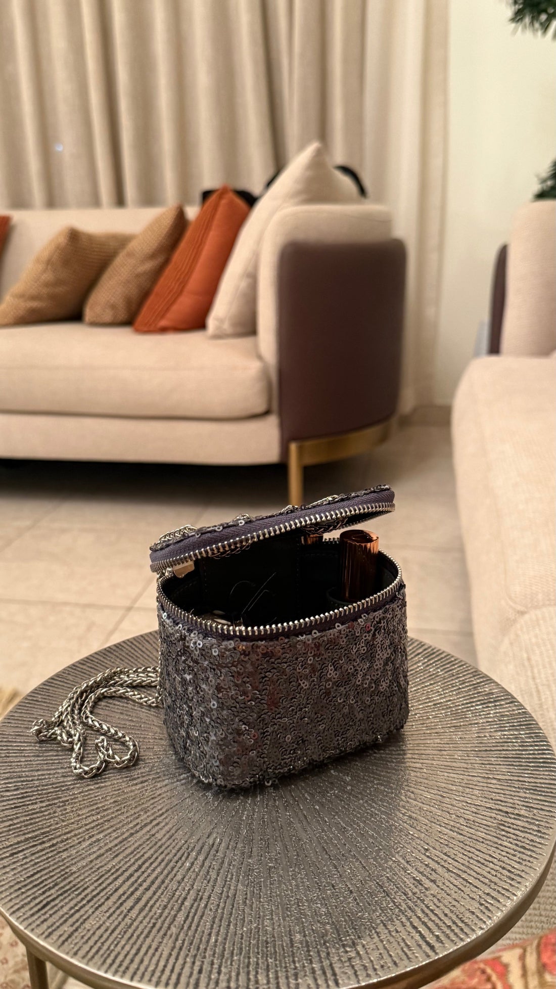 Small black bag on a round table in a living room setting