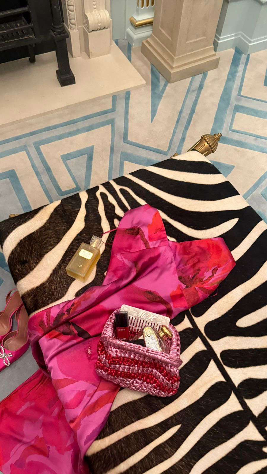 Zebra-patterned blanket with a pink fabric and small basket on a patterned floor.