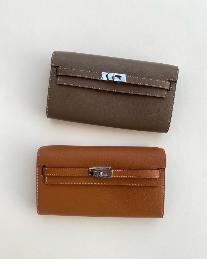 Two brown leather handbags with silver clasp on a light gray background