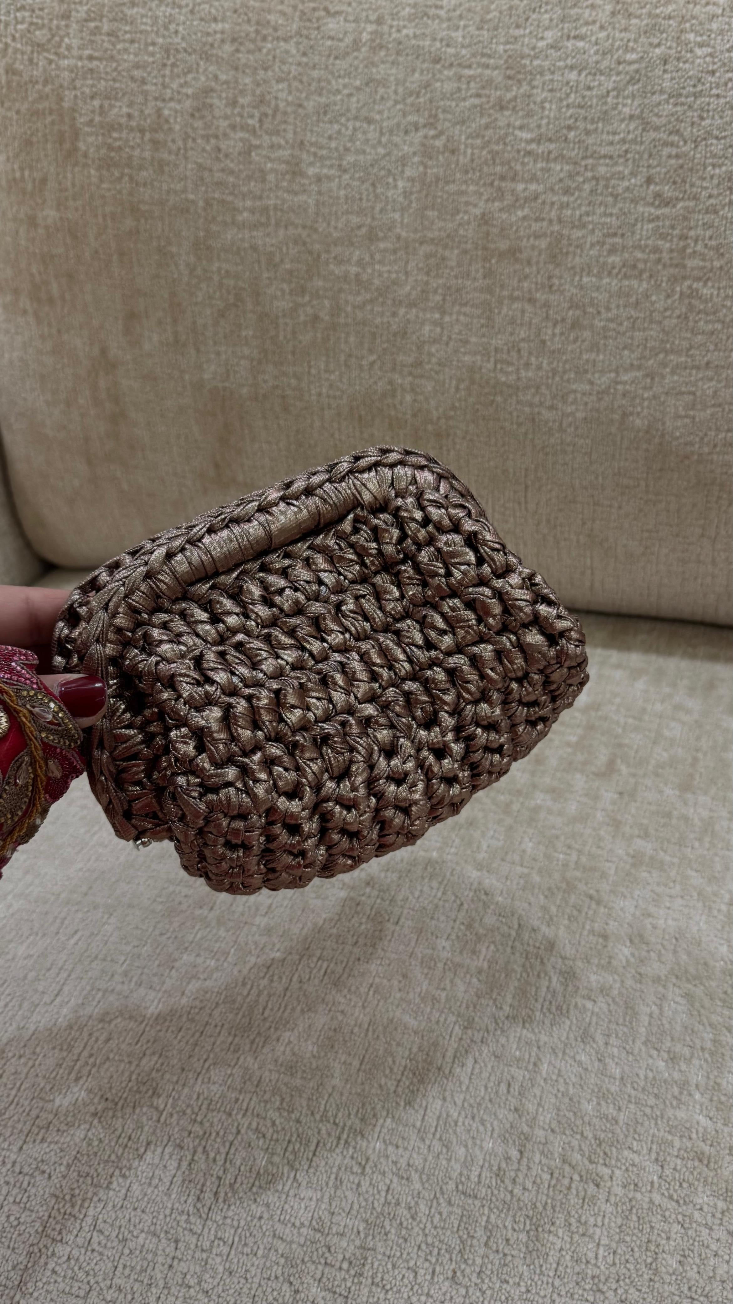 Brown woven pouch held against a beige sofa background