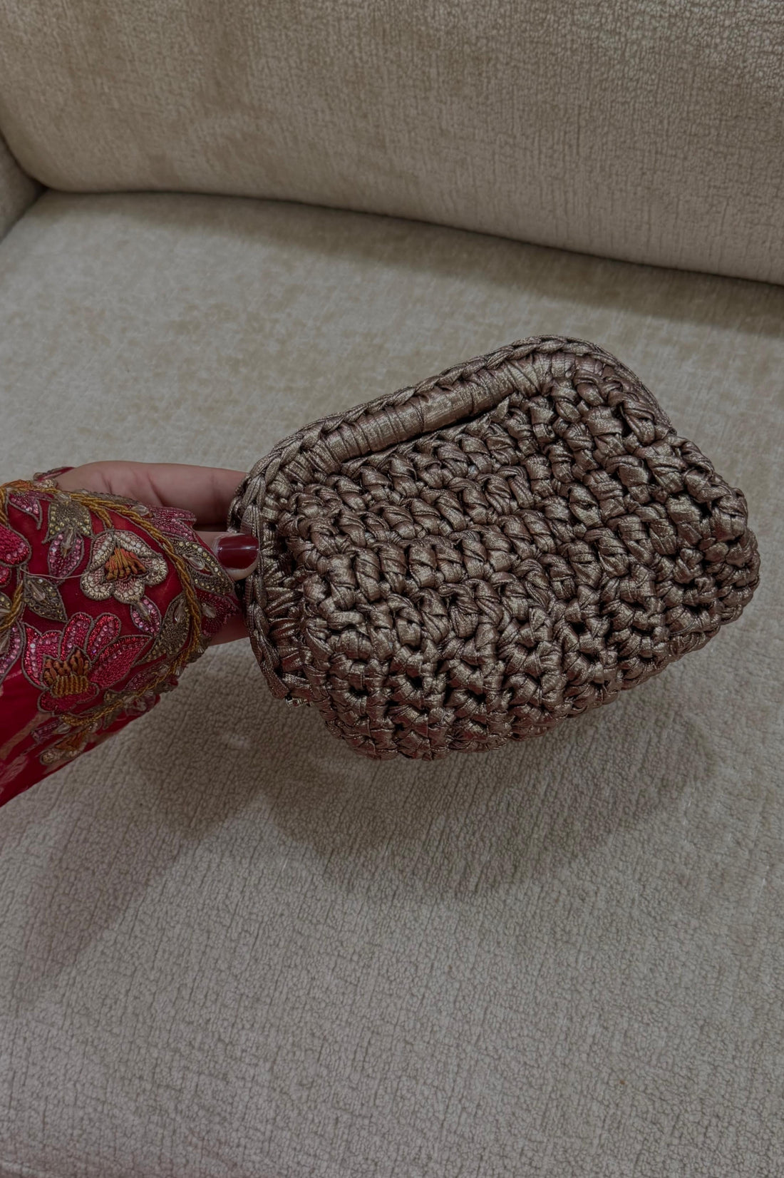 Textured brown clutch on a beige sofa