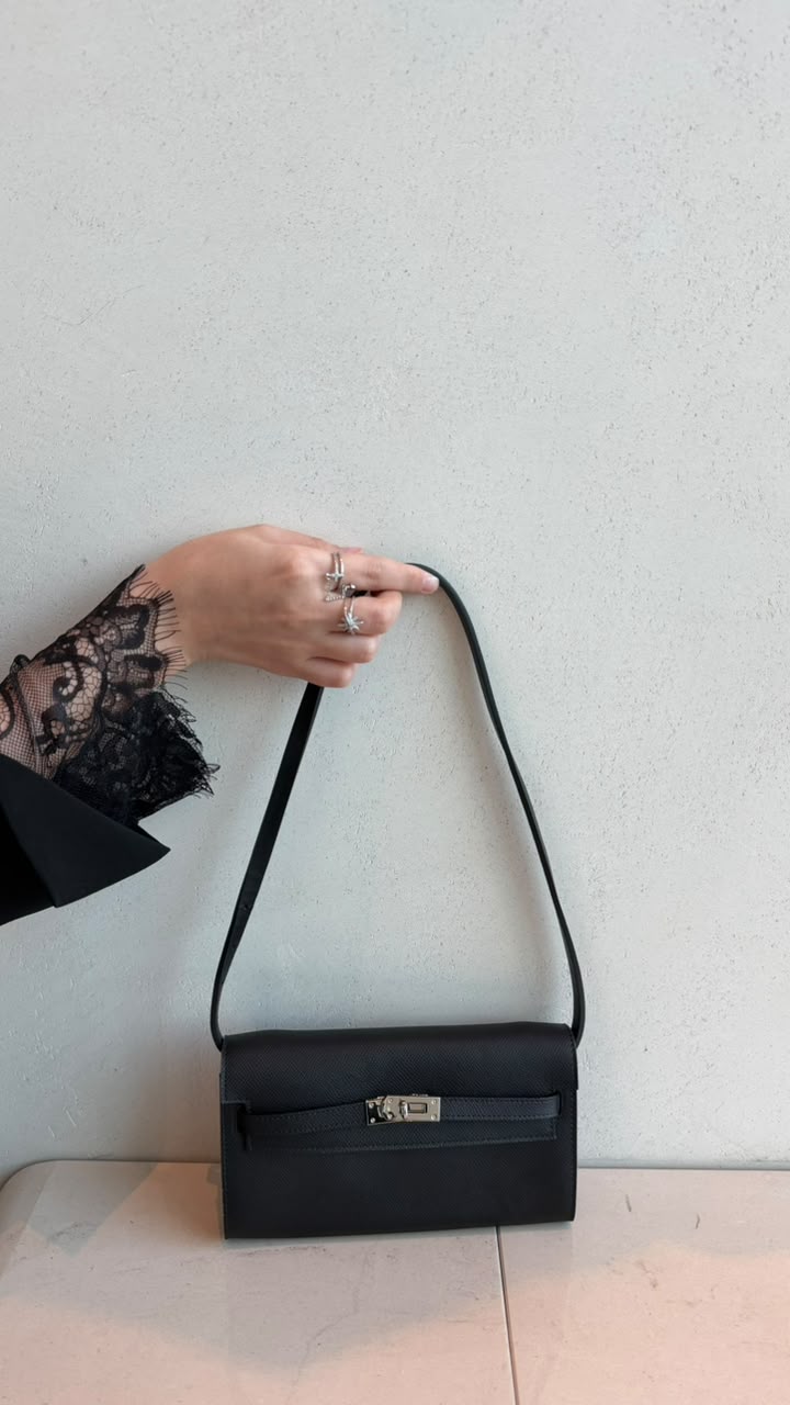 Kelly Black bag with shoulder strap held by hand with lace sleeve