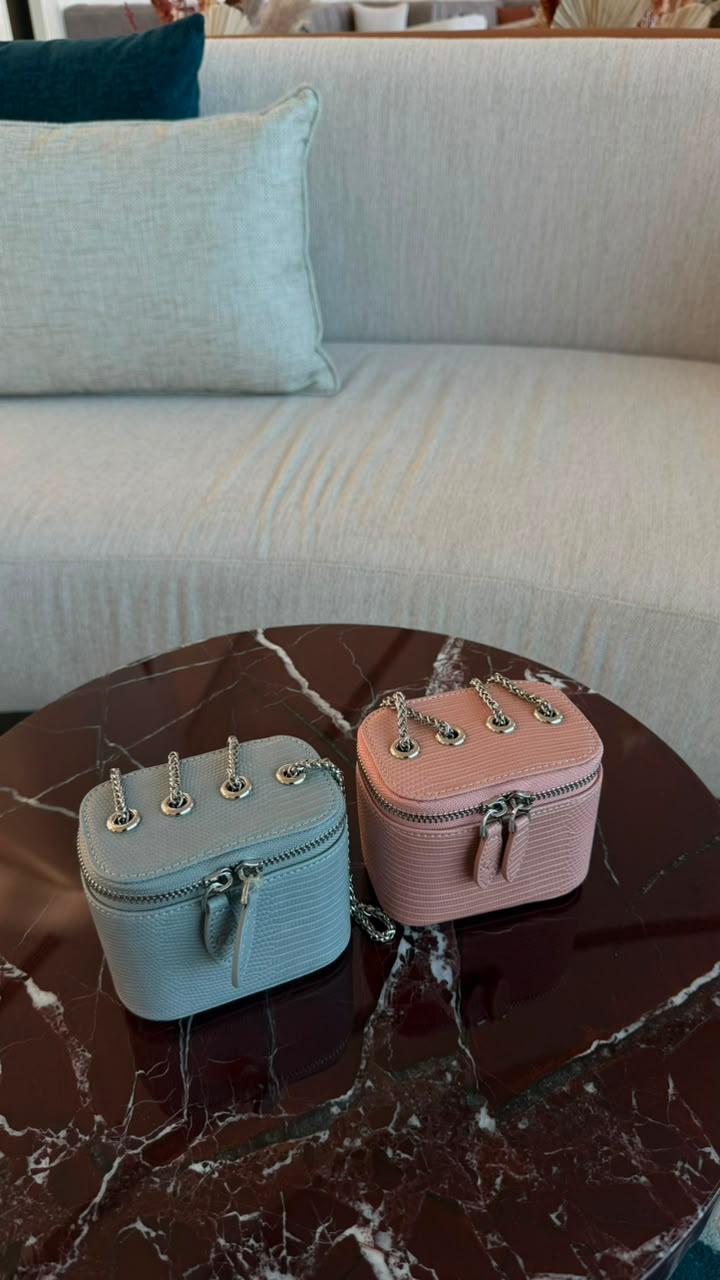 Mini Vanity Chain Bags in pink and blue top view on marble table