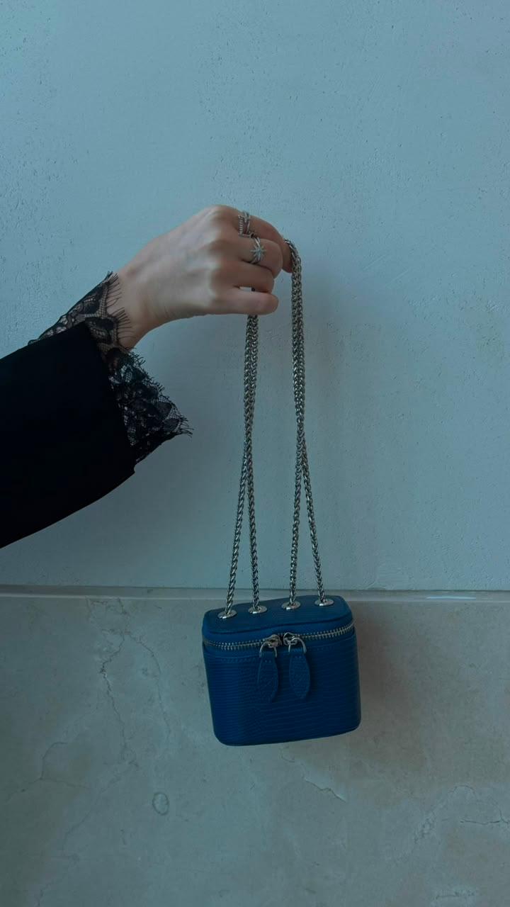 Mini Vanity Chain Bag Royal Blue hanging from chain strap held by hand with black lace sleeve