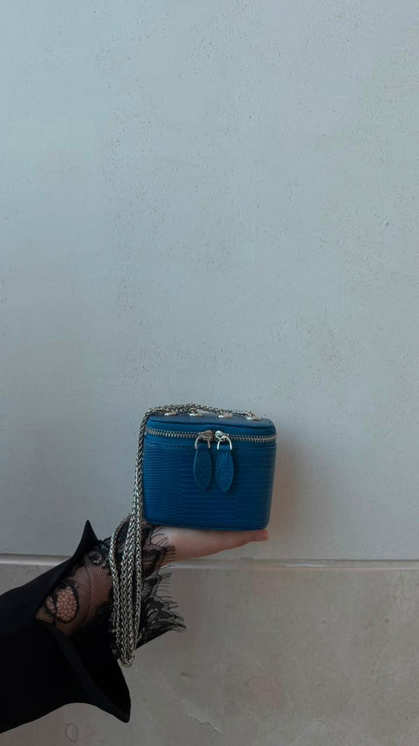 Mini Vanity Chain Bag Royal Blue held in palm of hand with black lace sleeve side view