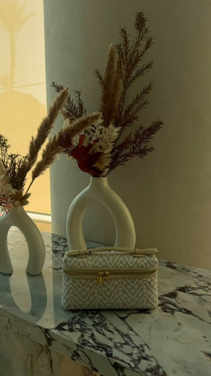 Quilted Chevron Vanity Bag in White – styled on marble surface with florals