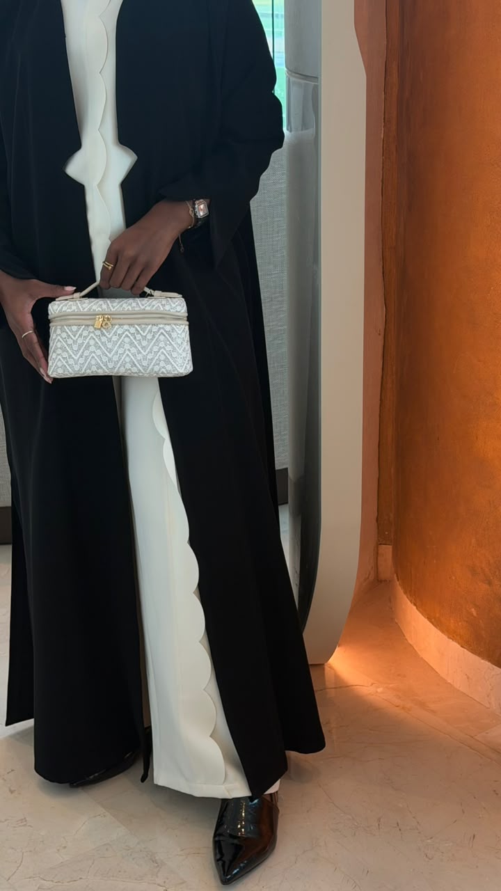 Quilted Chevron Vanity Bag in White – model holding bag against orange backdrop