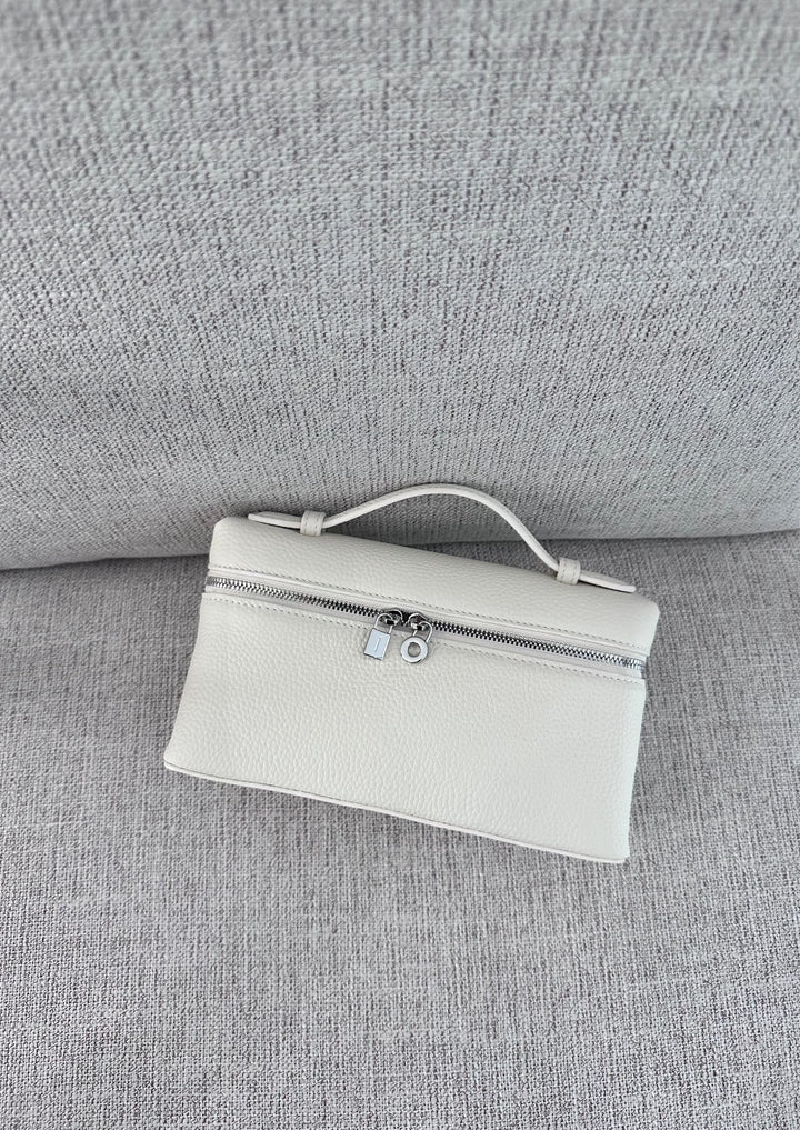 A white tote handbag with a minimalist design, placed on a grey textured surface.